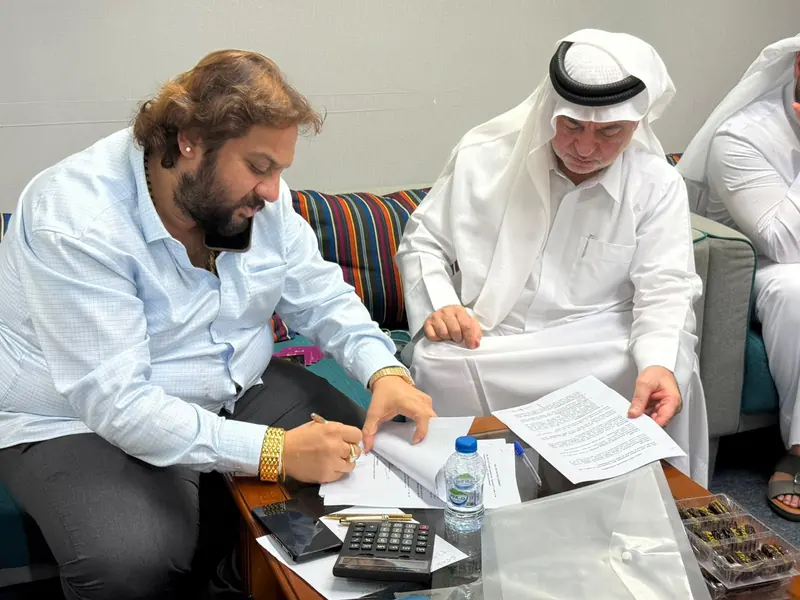 Documents being signed at a meeting with a guest in Emirati attire