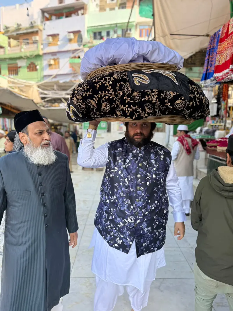 A man carrying a ceremonial cloth on his head in a market street